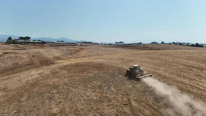 Mezzo al lavoro su un campo, ripreso dal drone