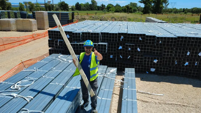 Operatore in sito tra i materiali di un impianto fotovoltaico